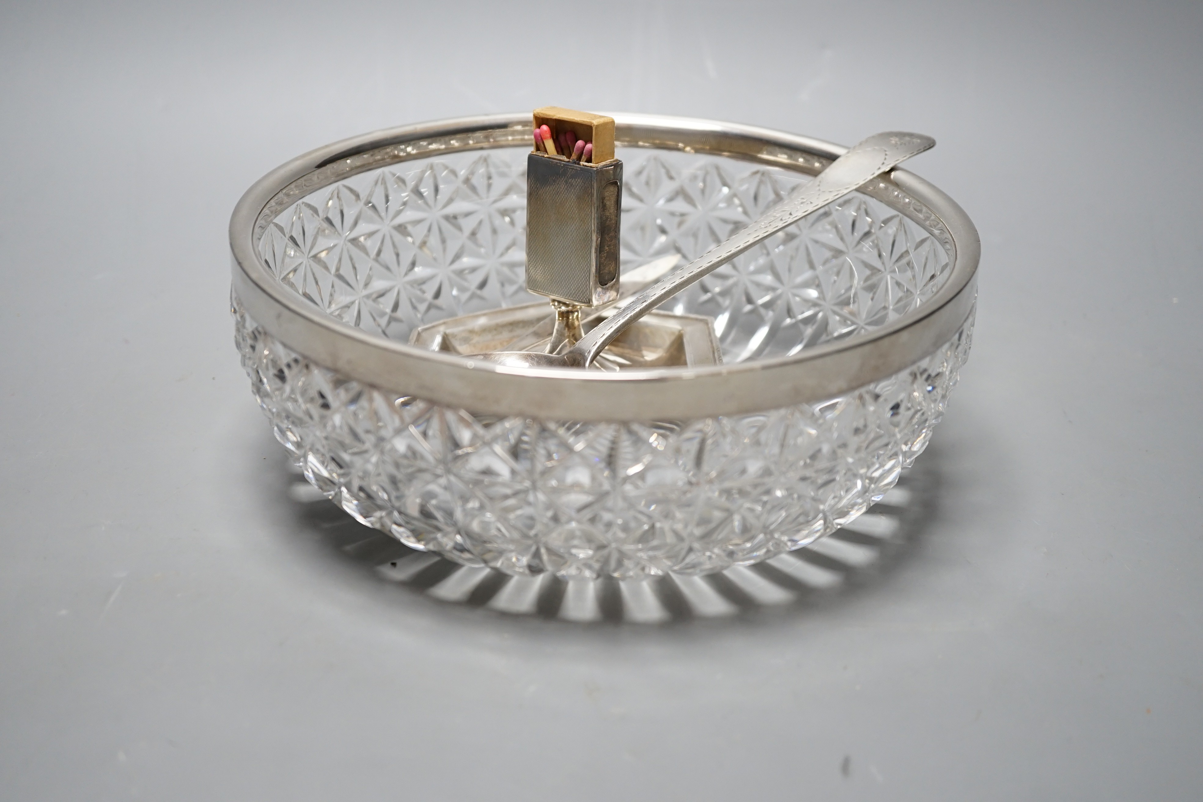 A George III Irish bright cut engraved silver tablespoon, Dublin, 1798, a silver match sleeve/ashtray, a silver rimmed fruit bowl fruit bowl and 925 letter opener.